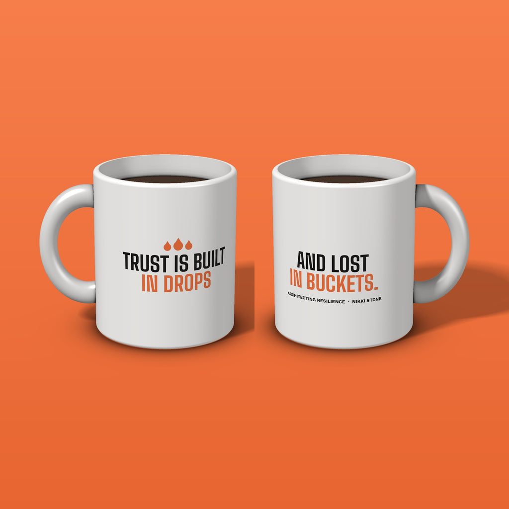 Both sides of the Trust Is Built in Drops mug on an orange background